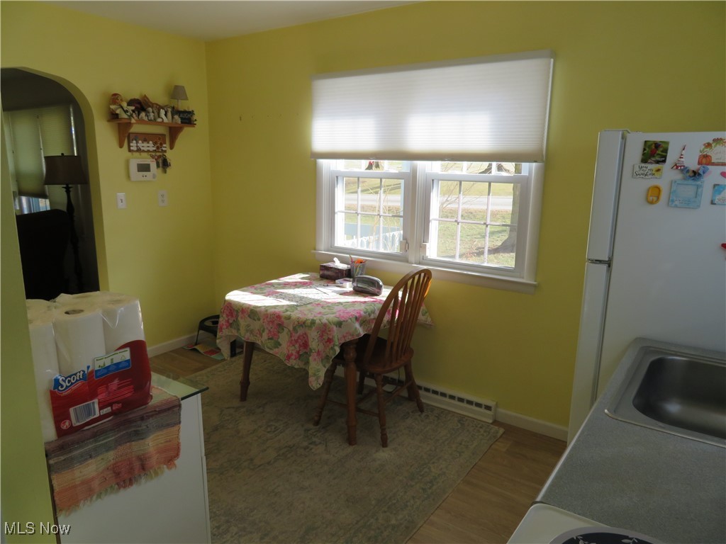 4358 Buss Road Wooster, OH 44691 - Photo 12 of 24 Dining space with arched walkways, a baseboard radiator, baseboards, and wood finished floors