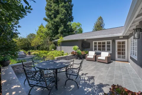 a bedroom with a bed a chandelier and a large window