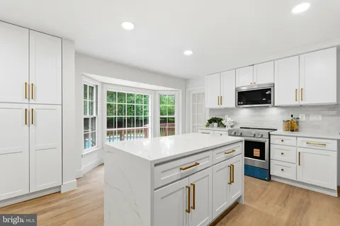 a kitchen with a sink a stove cabinets and wooden floor