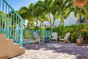 a view of a patio with table and chairs under an umbrella with a small yard