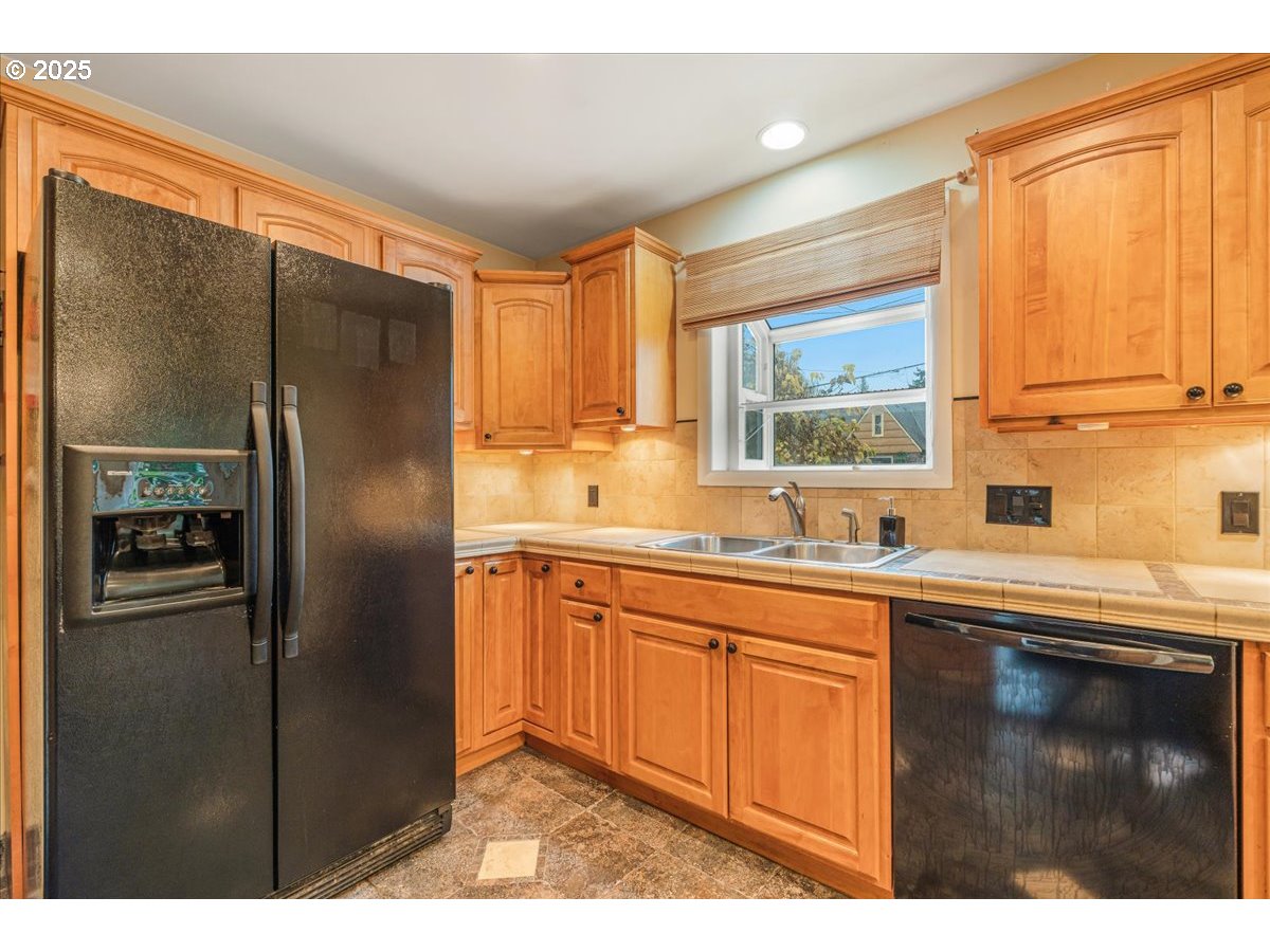 5925 Northeast 27th Avenue Portland, OR 97211 - Photo 11 of 25 a kitchen with stainless steel appliances granite countertop a refrigerator and a sink