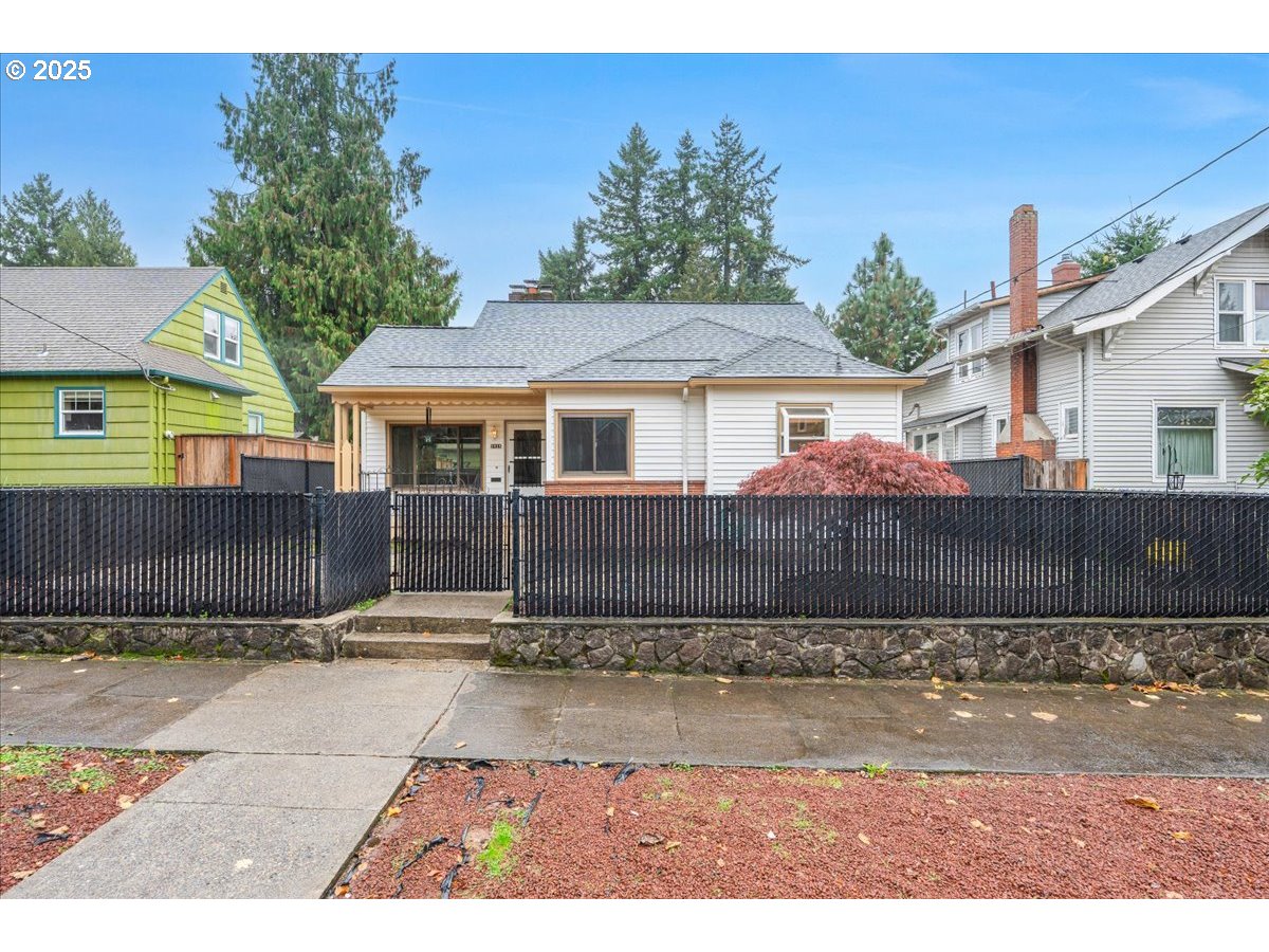 5925 Northeast 27th Avenue Portland, OR 97211 - Photo 2 of 25 a view of a house with a small yard and wooden fence