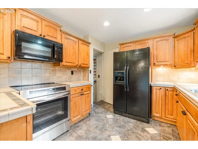 a kitchen with stainless steel appliances granite countertop a refrigerator stove and sink