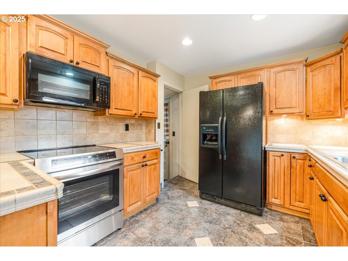 5925 Northeast 27th Avenue Portland, OR 97211 - Photo 8 of 25 a kitchen with stainless steel appliances granite countertop a refrigerator stove and sink