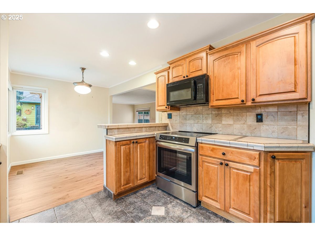 5925 Northeast 27th Avenue Portland, OR 97211 - Photo 9 of 25 a kitchen with stainless steel appliances granite countertop a stove a sink and a microwave