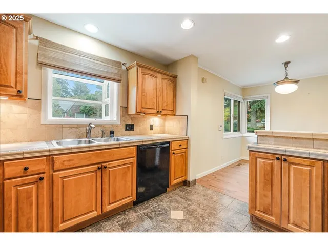 a kitchen with stainless steel appliances granite countertop a stove a sink dishwasher and a refrigerator