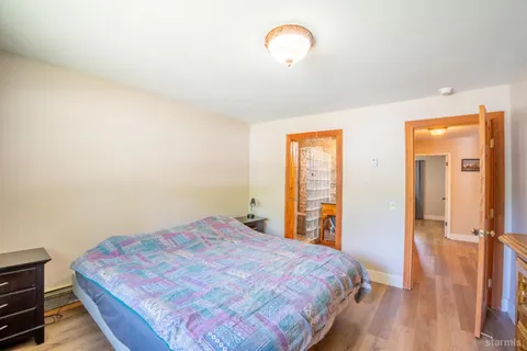 a bedroom with a bed and wooden floor