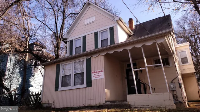 a front view of a house with a tree