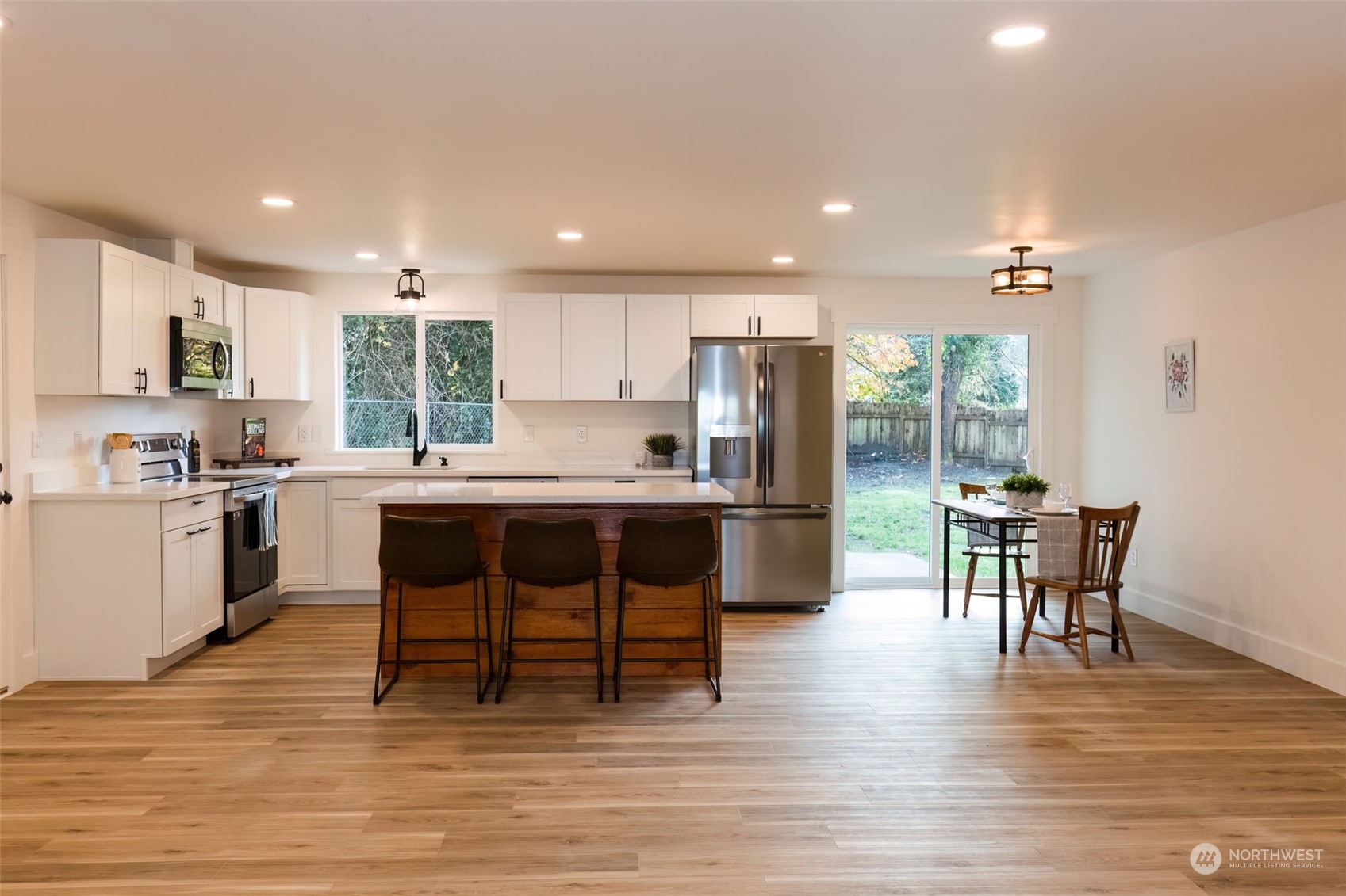 3719 Rhapsody Drive Southeast Port Orchard, WA 98366 - Photo 11 of 40 a kitchen with a table chairs refrigerator and cabinets
