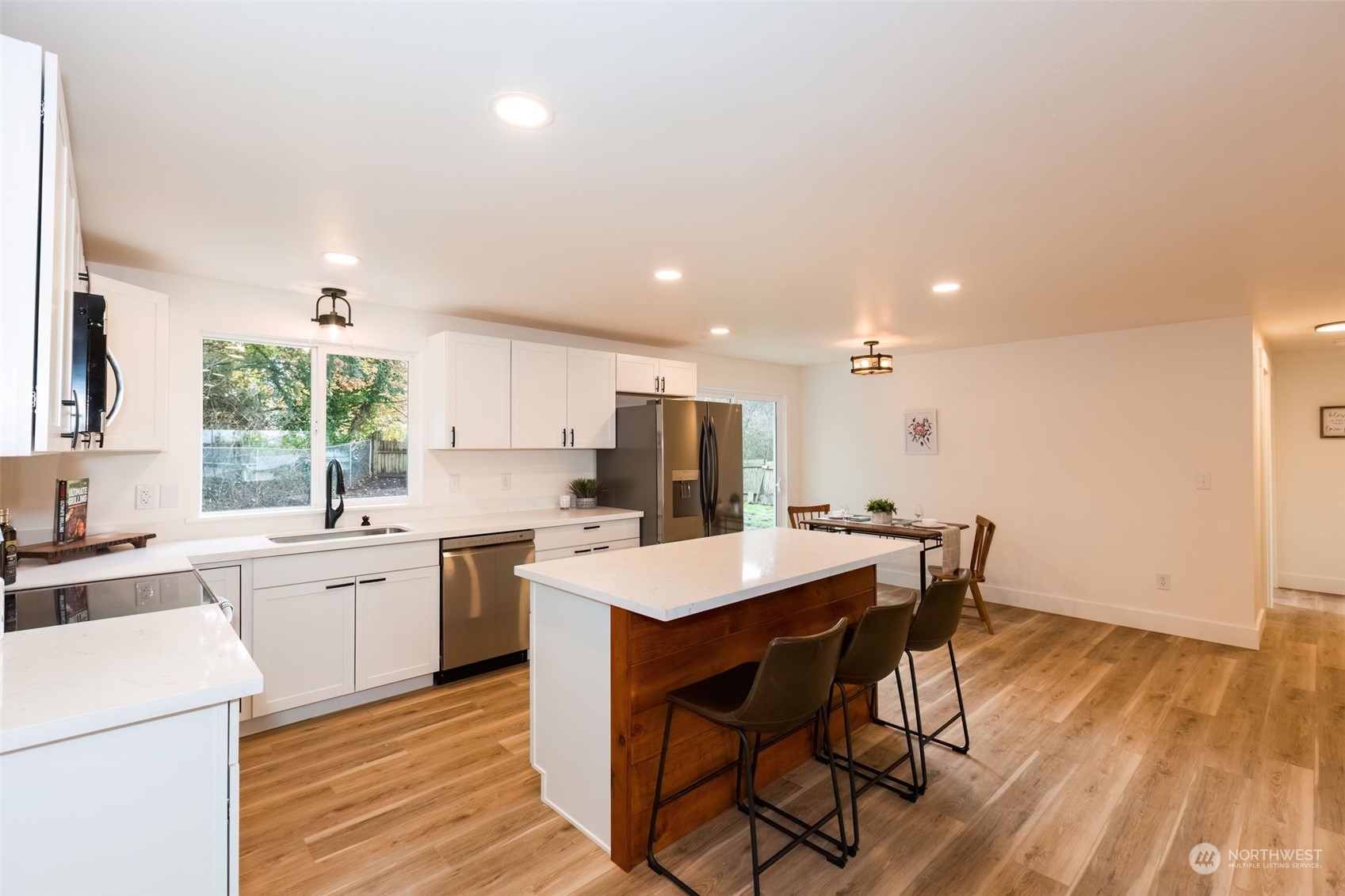 3719 Rhapsody Drive Southeast Port Orchard, WA 98366 - Photo 12 of 40 a kitchen with a table chairs sink and cabinets