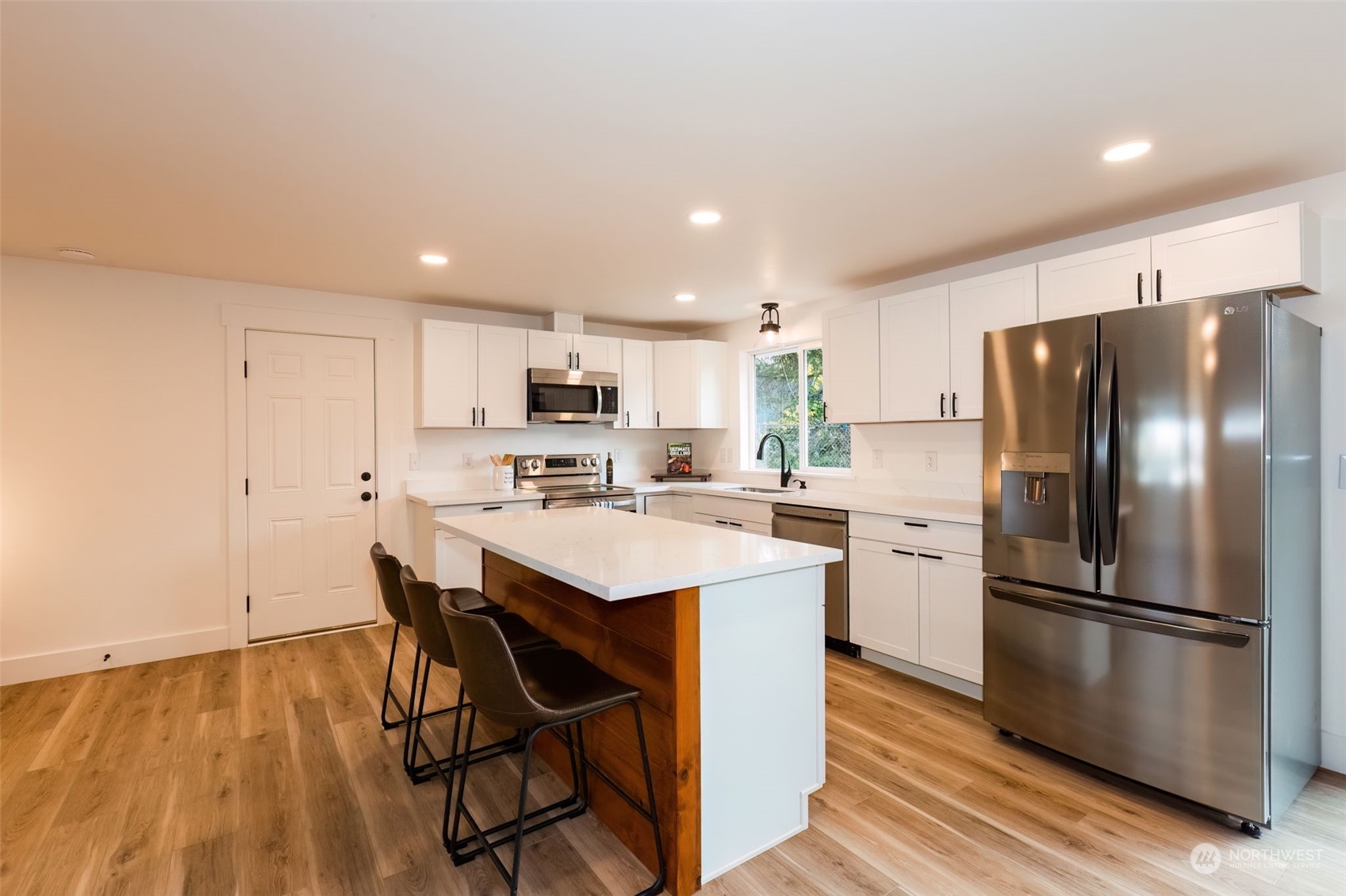 3719 Rhapsody Drive Southeast Port Orchard, WA 98366 - Photo 13 of 40 a kitchen with stainless steel appliances a refrigerator a stove a sink dishwasher and a refrigerator with wooden floor