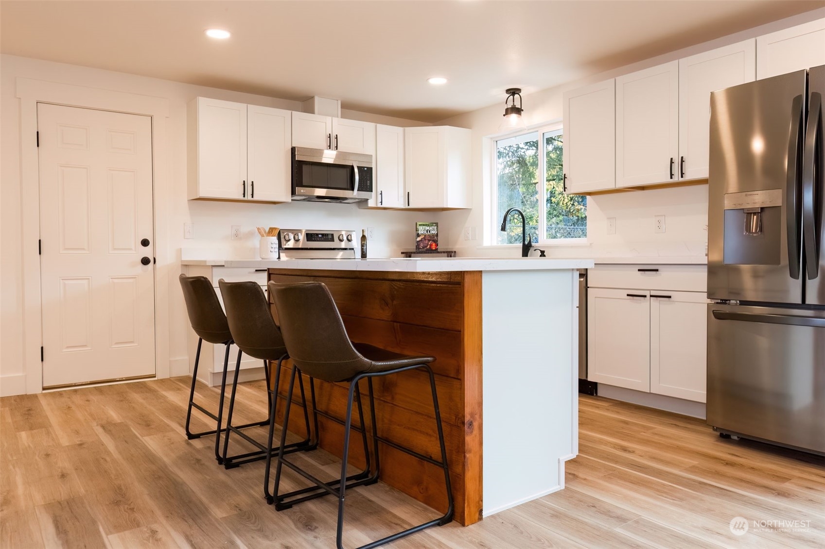 3719 Rhapsody Drive Southeast Port Orchard, WA 98366 - Photo 15 of 40 a kitchen with stainless steel appliances granite countertop a refrigerator a stove a sink dishwasher and white cabinets with wooden floor