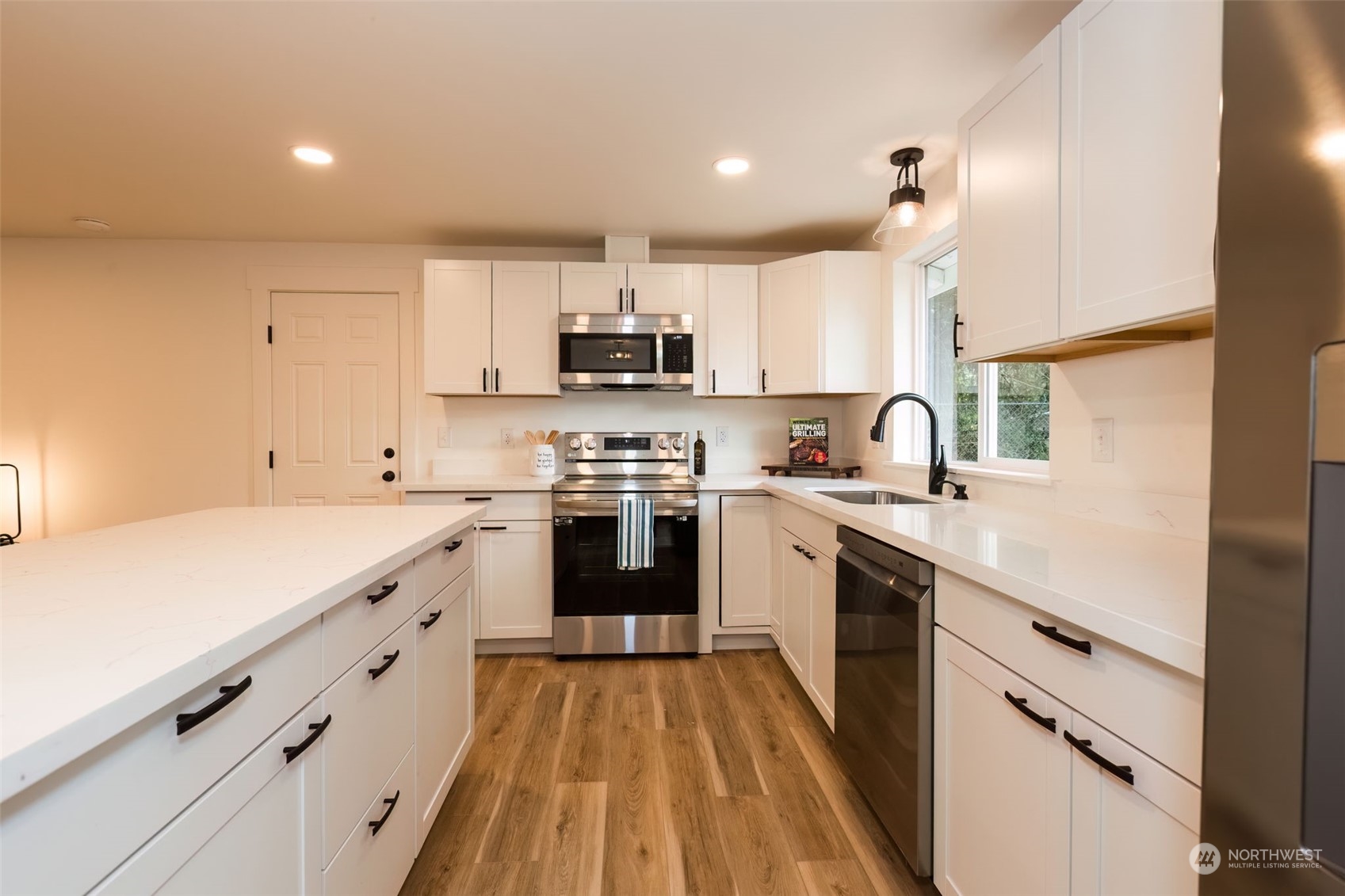 3719 Rhapsody Drive Southeast Port Orchard, WA 98366 - Photo 18 of 40 a kitchen with kitchen island white cabinets and white appliances
