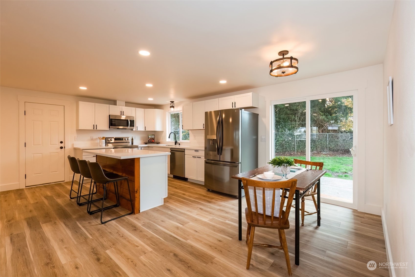 3719 Rhapsody Drive Southeast Port Orchard, WA 98366 - Photo 19 of 40 a kitchen with a table chairs refrigerator and microwave
