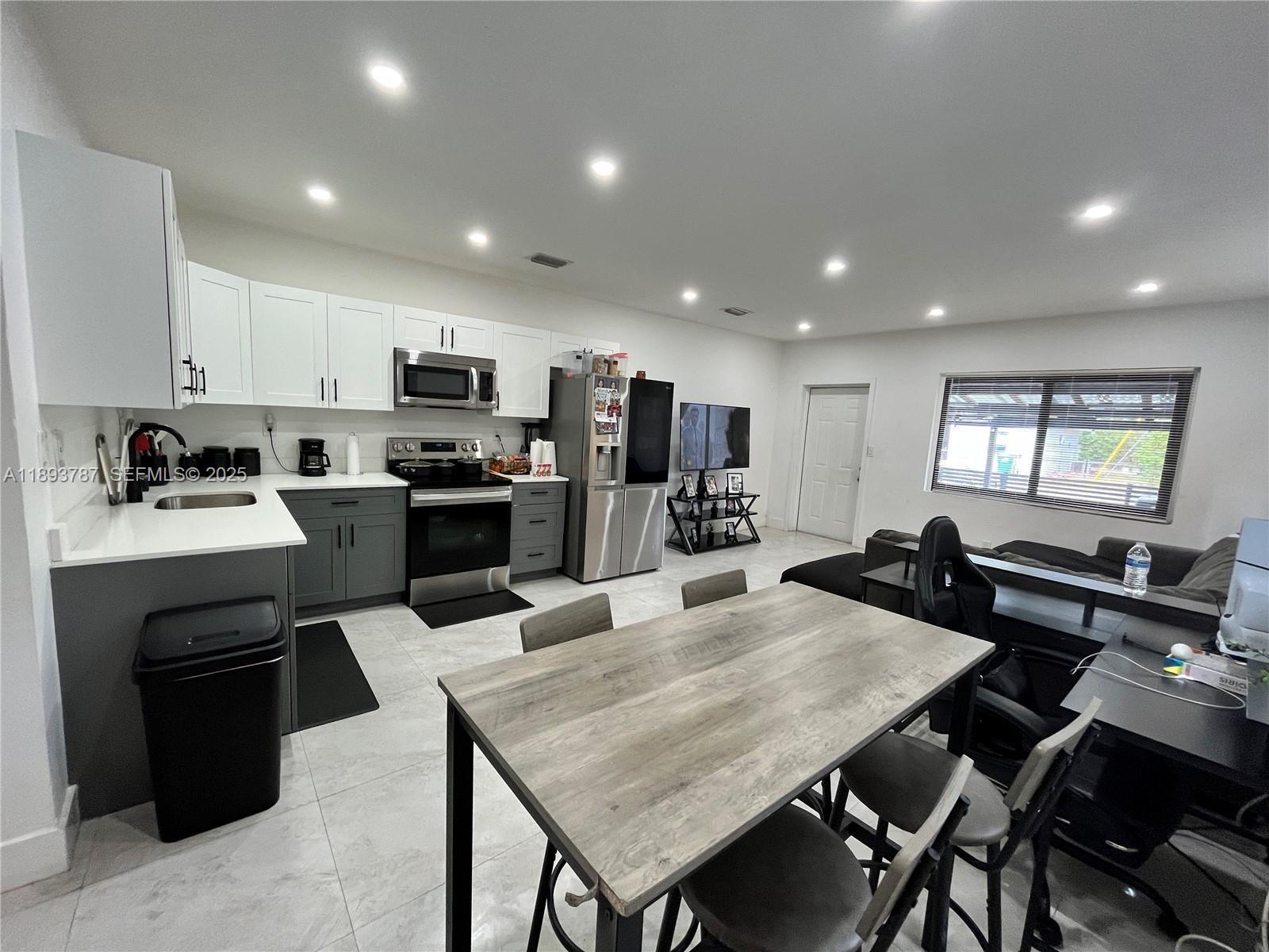 1102 Northwest 103rd Street Miami, FL 33150 - Photo 1 of 37 a kitchen with a dining table chairs and refrigerator