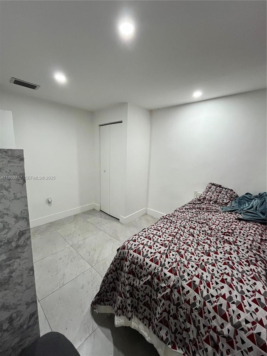 1102 Northwest 103rd Street Miami, FL 33150 - Photo 14 of 37 a bedroom with a bed and a painting on the wall