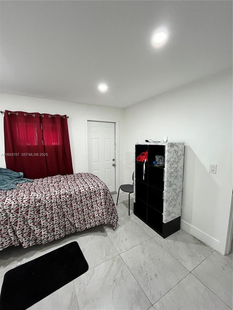 1102 Northwest 103rd Street Miami, FL 33150 - Photo 15 of 37 a bedroom with a bed and a window