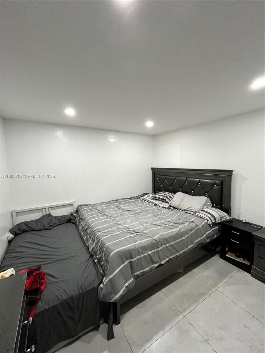 1102 Northwest 103rd Street Miami, FL 33150 - Photo 16 of 37 a bedroom with a bed and a lamp