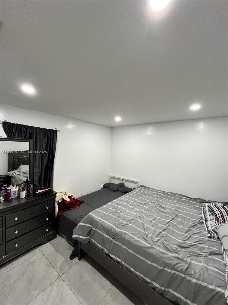 1102 Northwest 103rd Street Miami, FL 33150 - Photo 17 of 37 a bedroom with a bed window and a television