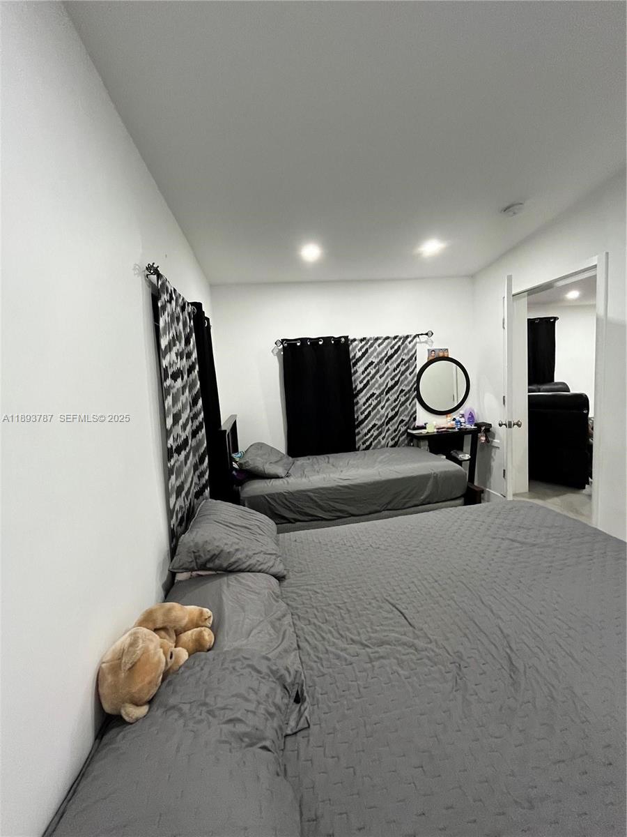 1102 Northwest 103rd Street Miami, FL 33150 - Photo 19 of 37 a bedroom with a bed and a chandelier