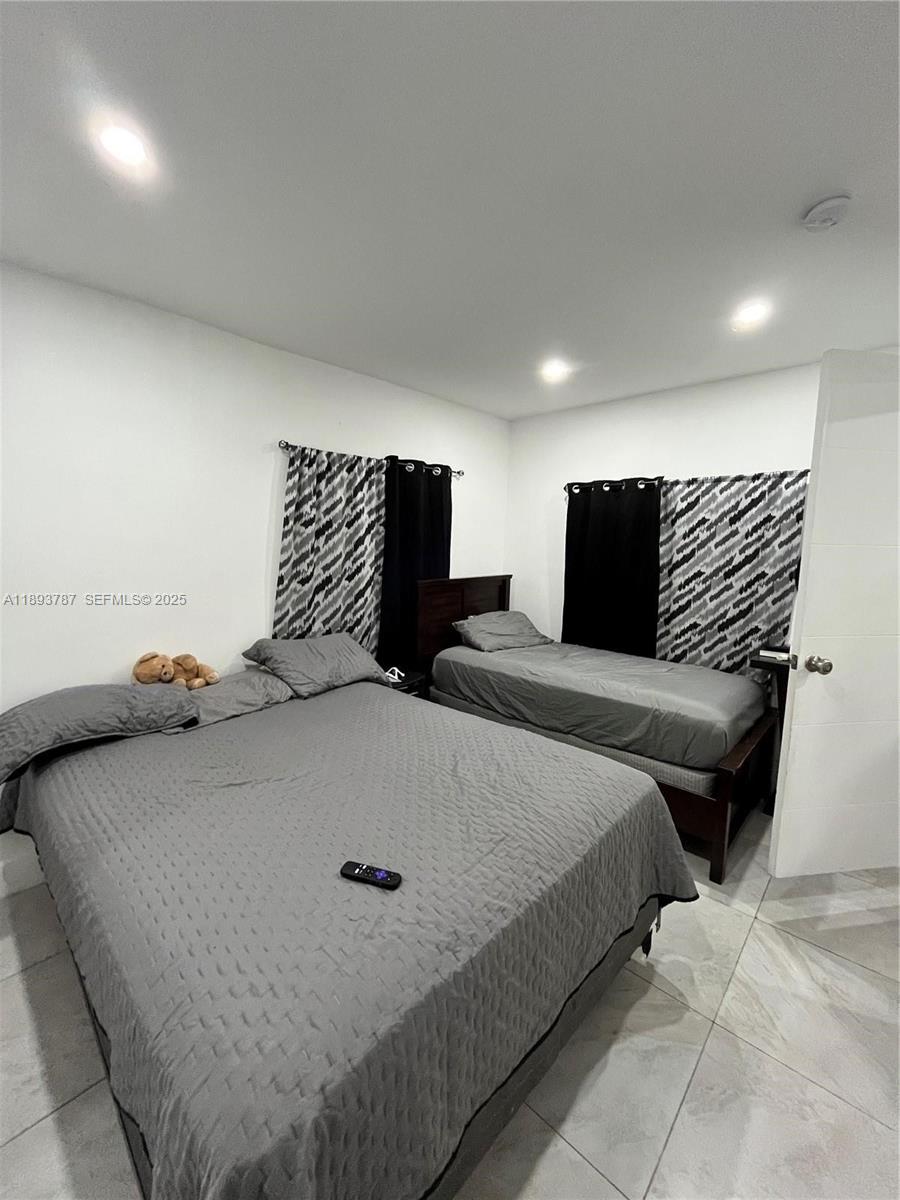 1102 Northwest 103rd Street Miami, FL 33150 - Photo 20 of 37 a bedroom with bed and a night stand