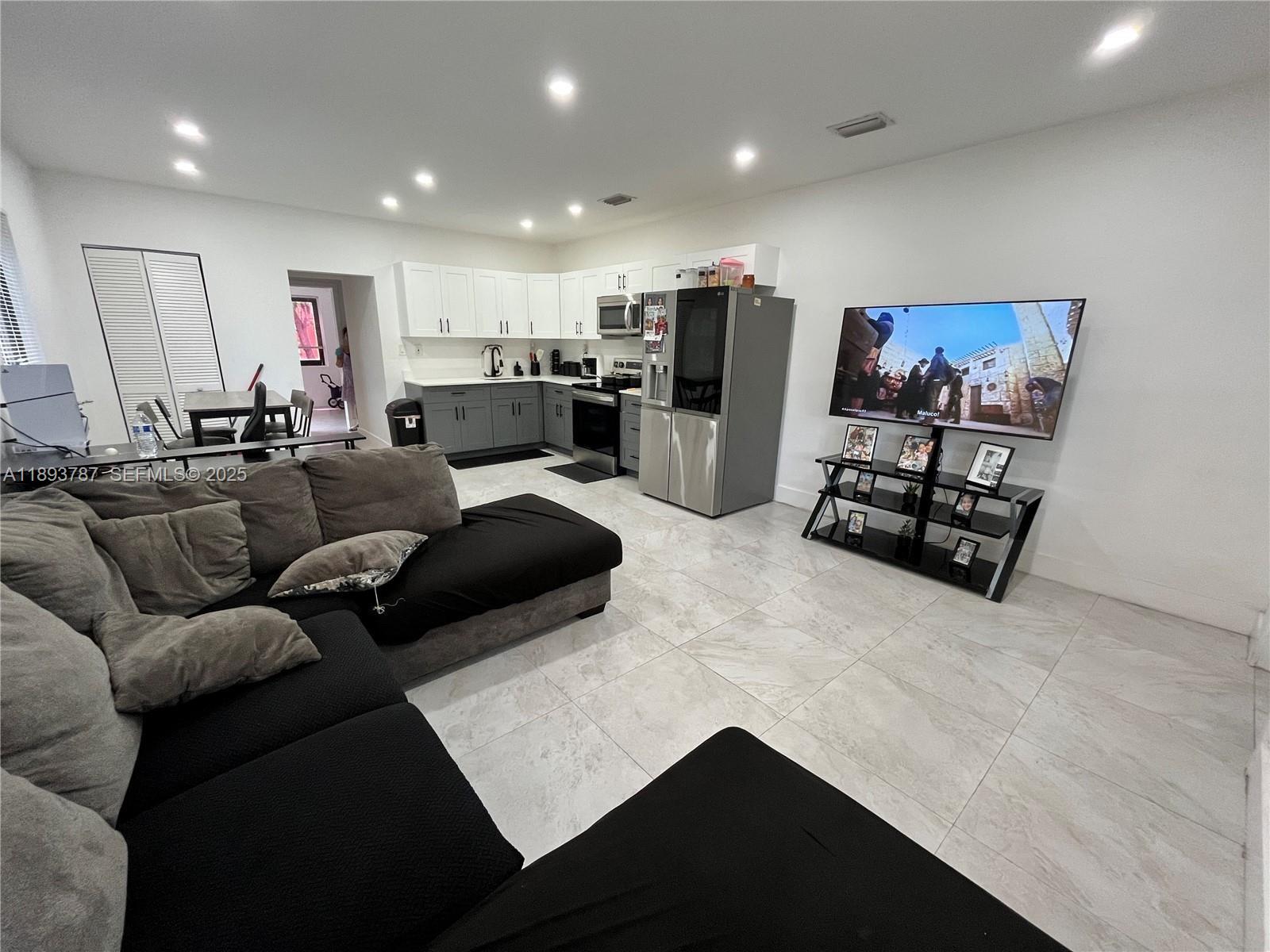 1102 Northwest 103rd Street Miami, FL 33150 - Photo 2 of 37 a living room with furniture and a flat screen tv