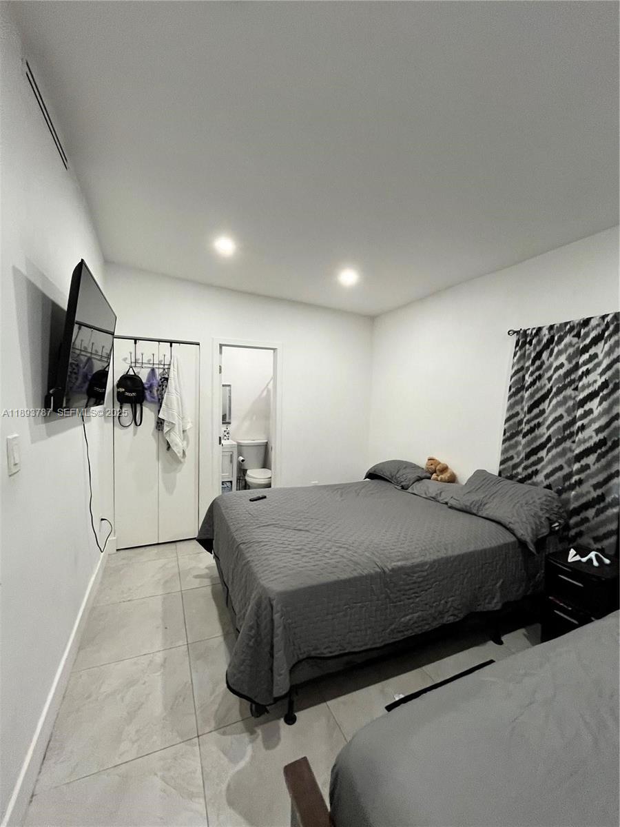 1102 Northwest 103rd Street Miami, FL 33150 - Photo 21 of 37 a bedroom with a bed and a flat screen tv