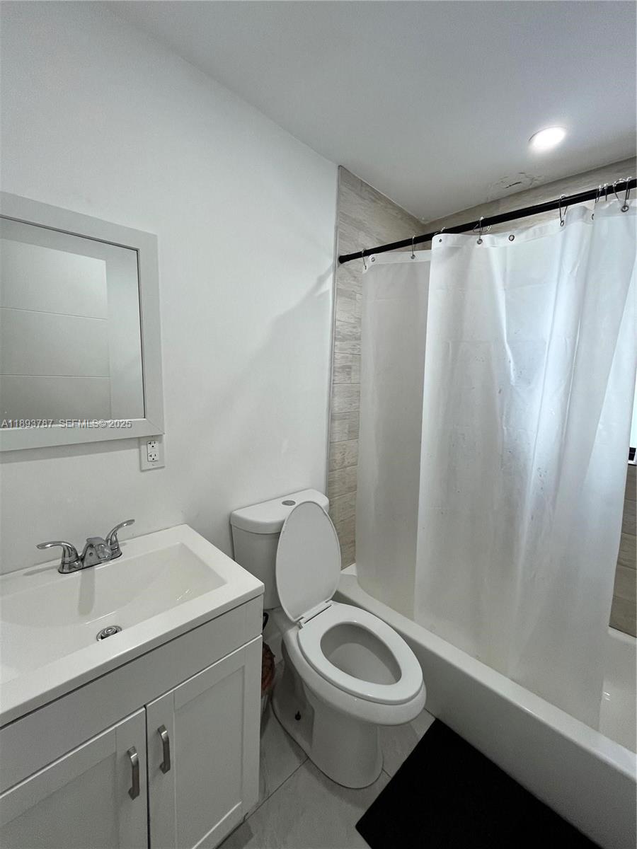 1102 Northwest 103rd Street Miami, FL 33150 - Photo 22 of 37 a white toilet sitting next to a bathroom sink