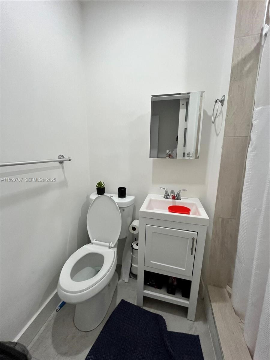 1102 Northwest 103rd Street Miami, FL 33150 - Photo 23 of 37 a bathroom with a toilet and a shower