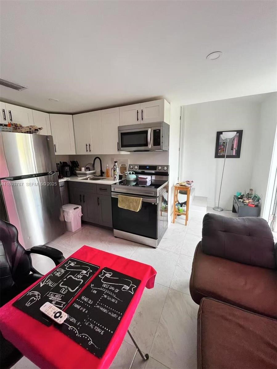 1102 Northwest 103rd Street Miami, FL 33150 - Photo 26 of 37 a kitchen with stainless steel appliances granite countertop a stove a sink dishwasher a refrigerator and a stove