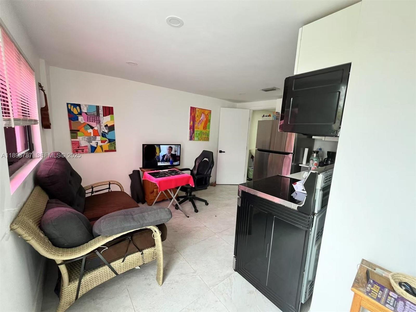 1102 Northwest 103rd Street Miami, FL 33150 - Photo 27 of 37 a living room with furniture and a flat screen tv