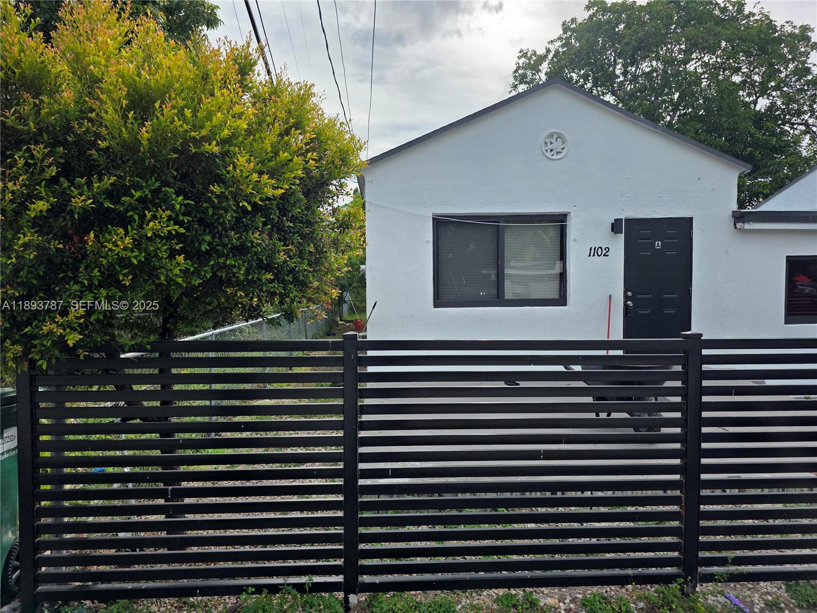 1102 Northwest 103rd Street Miami, FL 33150 - Photo 33 of 37 a front view of a house with a tree