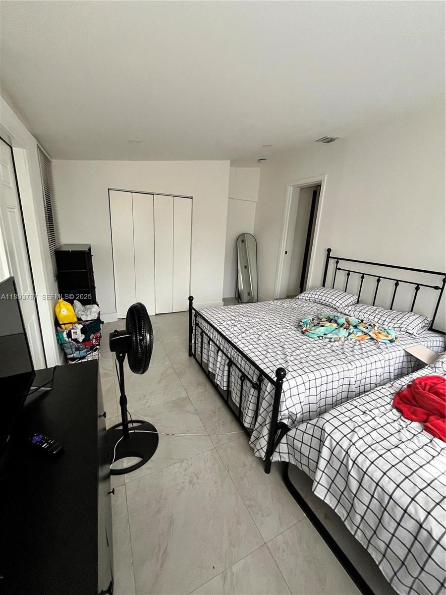 1102 Northwest 103rd Street Miami, FL 33150 - Photo 8 of 37 a bedroom with furniture and a flat screen tv