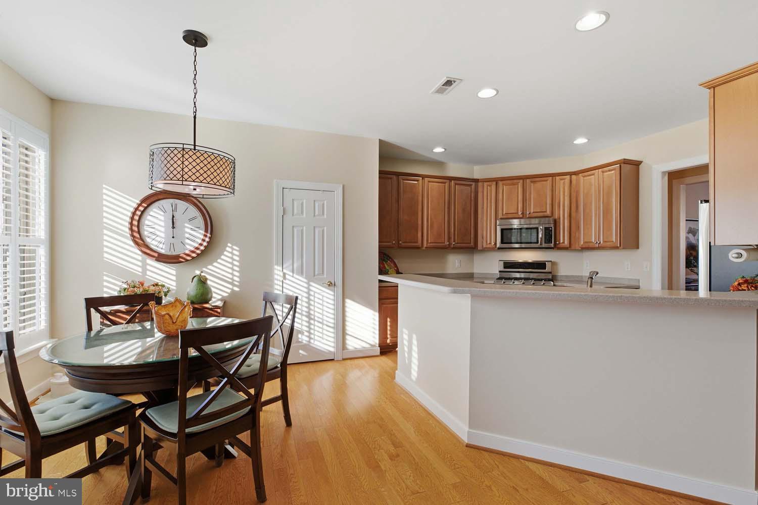 464 Middle Gate Irvington, VA 22480 - Photo 15 of 46 a kitchen with stainless steel appliances granite countertop a stove top oven a refrigerator a dining table and chairs with wooden floor