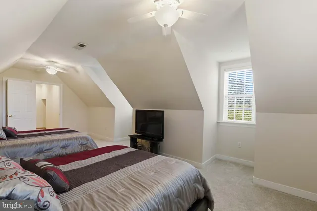a bedroom with a bed and a flat tv screen on a dresser