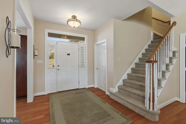 a view of a hallway with wooden floor and entryway