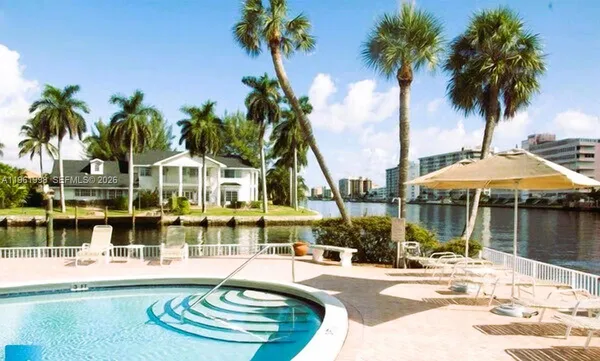 a view of a swimming pool with a lawn chair and palm chairs