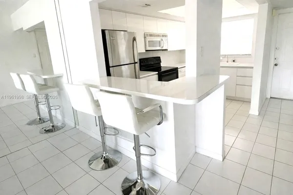 a kitchen with stainless steel appliances kitchen island granite countertop a refrigerator and cabinets