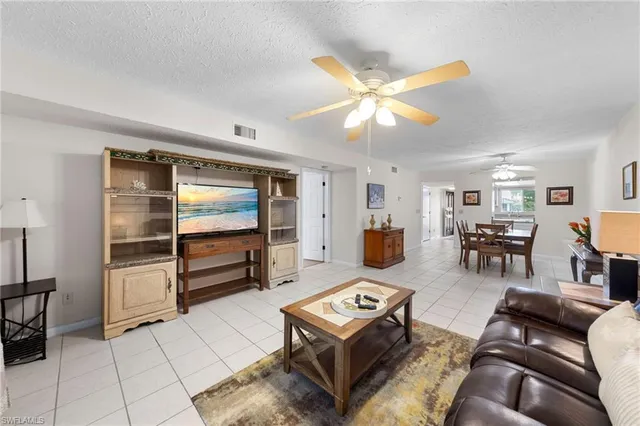 a living room with furniture and view of kitchen