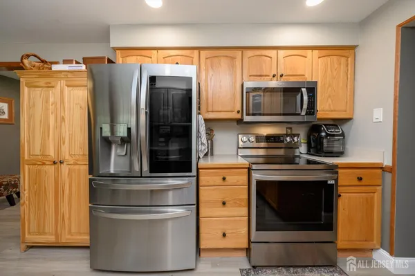 a kitchen with stainless steel appliances granite countertop a refrigerator and a stove top oven
