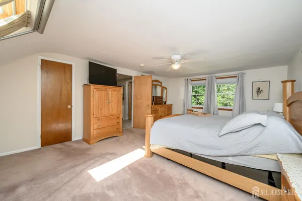 a bed sitting in a spacious bedroom next to a window