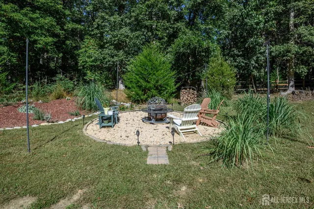 a view of a white house with a yard table and chairs