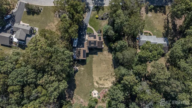 an aerial view of house with yard and trees all around