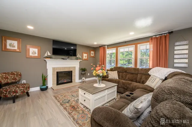 a living room with furniture a fireplace and a flat screen tv