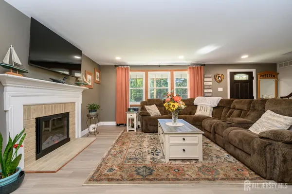 a living room with furniture a large window and a fireplace