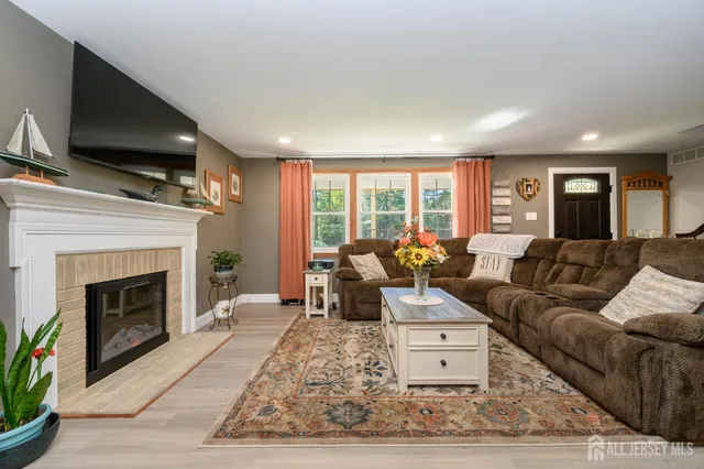 a living room with furniture a large window and a fireplace