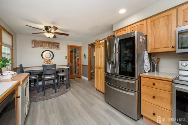 a kitchen with granite countertop stainless steel appliances refrigerator dining table and chairs