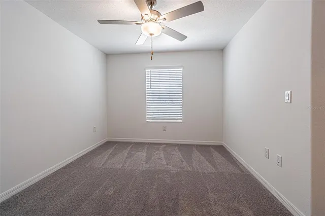 an empty room with closet and a ceiling fan