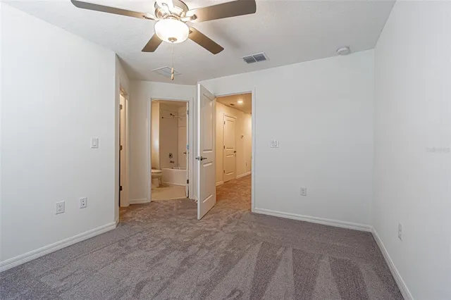 a bathroom with a granite countertop sink toilet mirror and bathtub