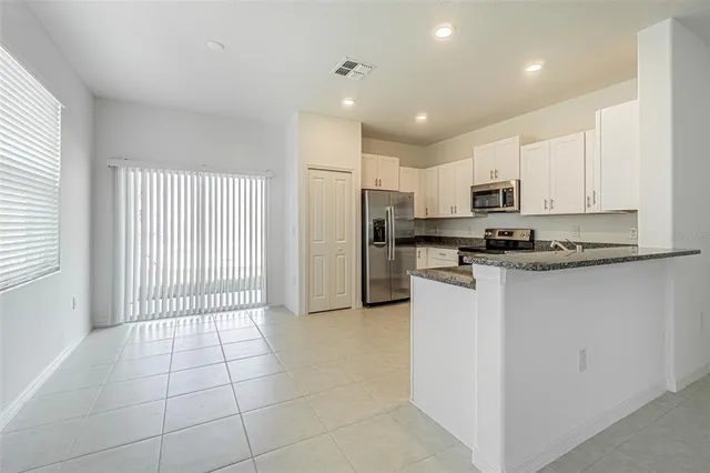 a kitchen with stainless steel appliances granite countertop a refrigerator and a stove top oven